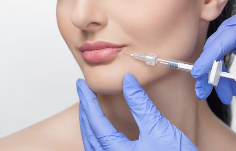Lip augmentation procedure of a beautiful woman in a beauty salon.