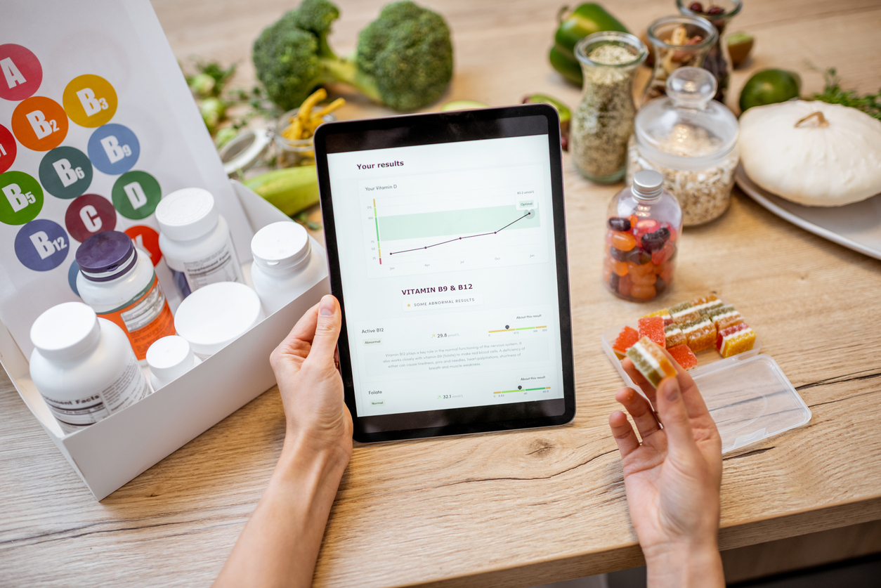 Woman checking result of medical tests on tablet with nutritional supplements